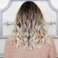 Beautiful woman with balayage hairstyle back view. Lovely modern and fashion hairstyles. Curly short or long hair. Space for text